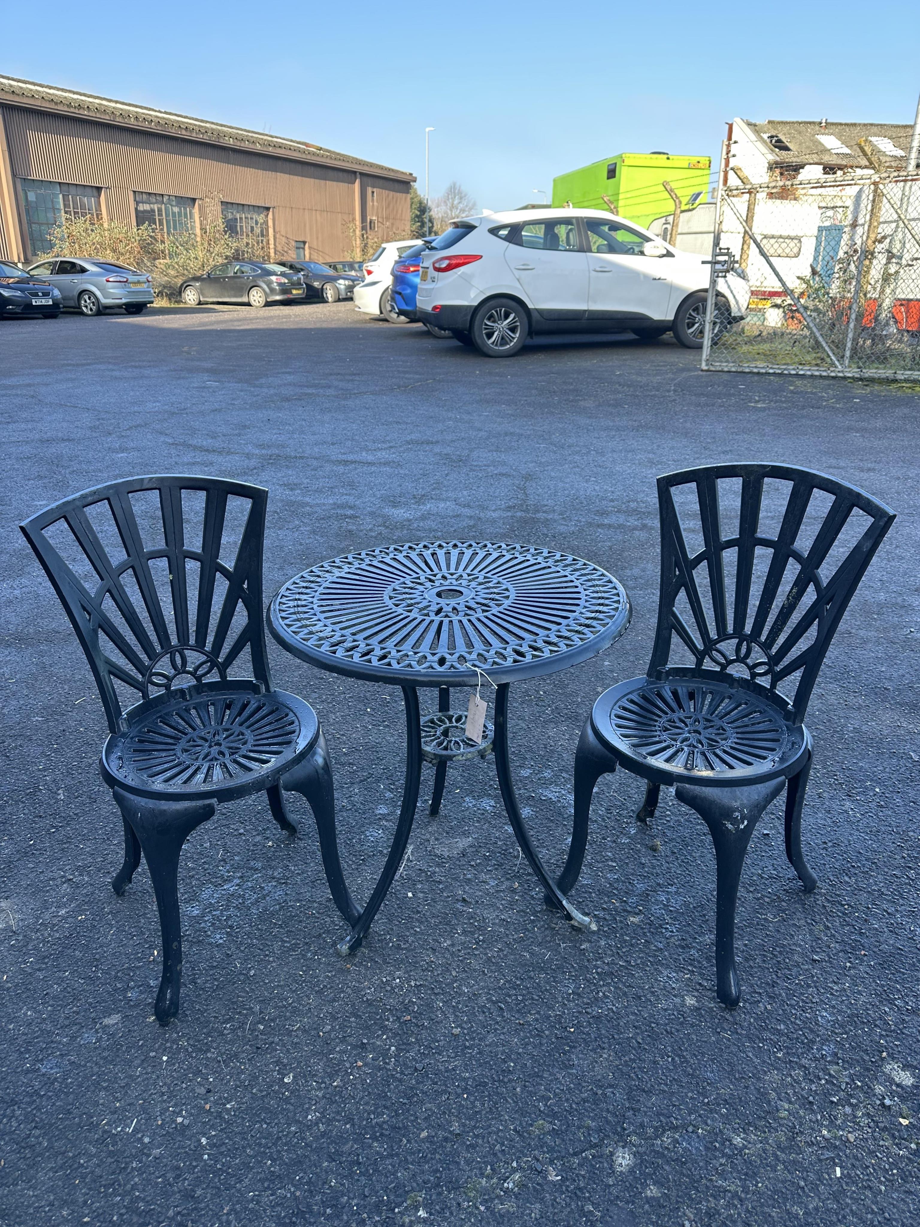 An aluminium garden table, diameter 65cm and a pair of chairs. Condition - poor